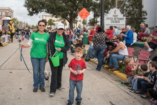 Team Mainstreet handing out candy along the parade route during Mardi Gras on Mainstreet