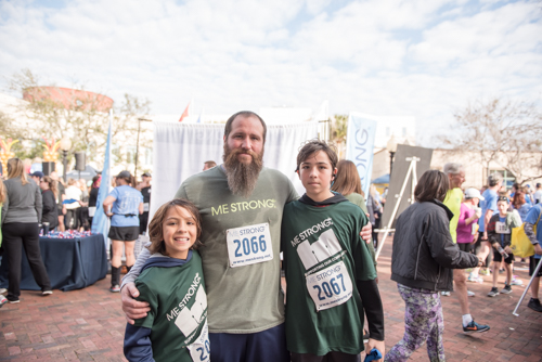 Family members of Team Mainstreet smiling for a photo after running in the MeStrong 5k race in DeLand