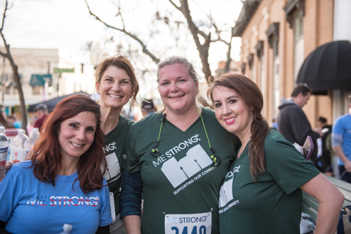 Four members of Team Mainstreet smiling for a photo after running in the MeStrong 5k race in DeLand