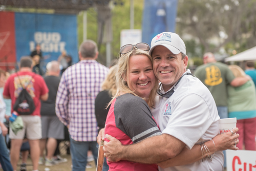 Man and woman hugging during Pig on the Pond event in Clermont