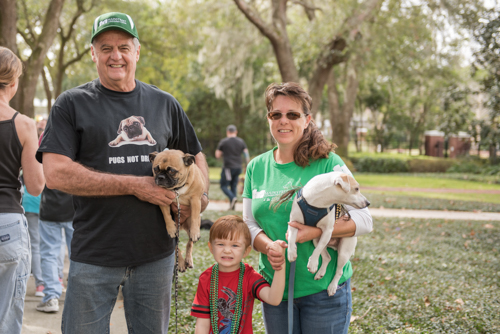 Team Mainstreet posing for a picture with their dogs before the Mardi Gras dog parade in DeLand.