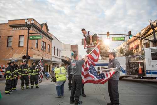 Firefighters hanging up US Flag before MeStrong 5k race in downtown DeLand