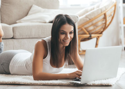 girl laying on floor on laptop 