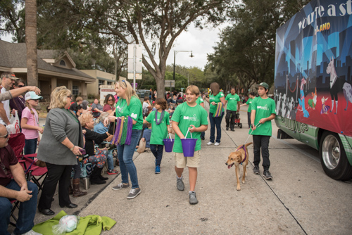 Team Mainstreet handing out candy along the parade route at the Mardi Gras dog parade in DeLand