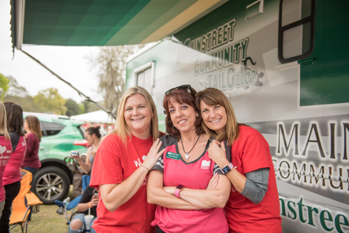 A group of ladies smiling for a photo in front of the Mainstreet RV at Pig on the Pond