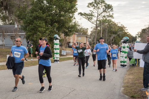 Members of Team Mainstreet waving while running in the MeStrong 5k race in DeLand