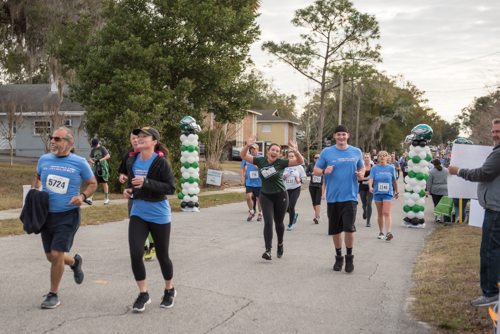 Members of Team Mainstreet waving while running in the MeStrong 5k race in DeLand