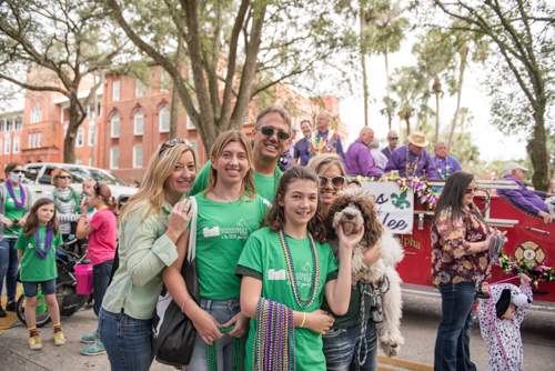 Team Mainstreet posing for a picture with their dog before the Mardi Gras dog parade in DeLand