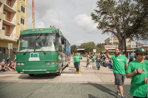 Team Mainstreet waving at spectators along the parade route at the Mardi Gras dog parade in DeLand