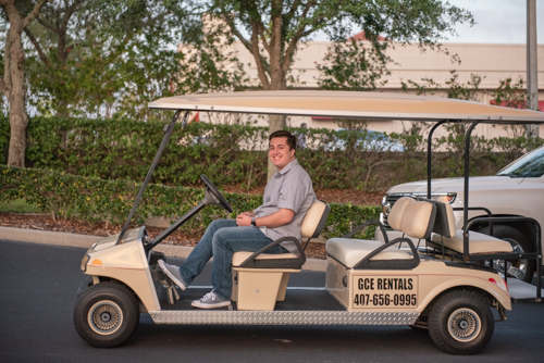 Member of Team Mainstreet driving golf cart during Clermont's 2nd anniversary celebration