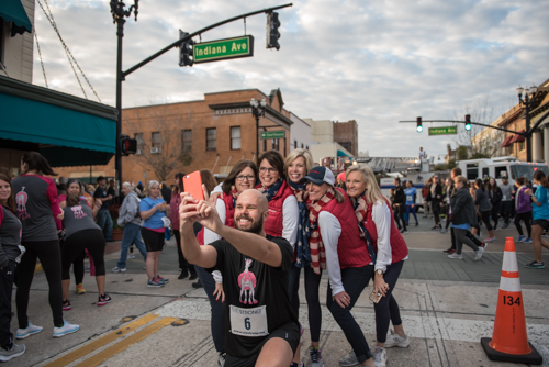 A runner taking a selfie with MeStrong founders before MeStrong 5k race in Downtown DeLand