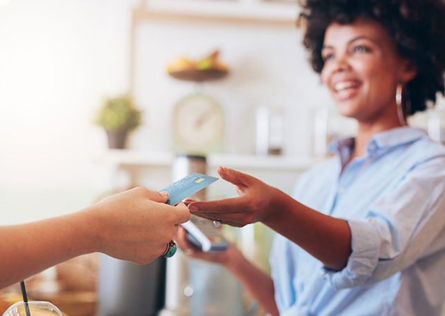 Young woman accepting payment at a coffee shop.