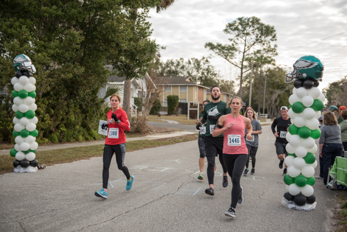 A member of Team Mainstreet running in a crowd during the MeStrong 5k race in DeLand