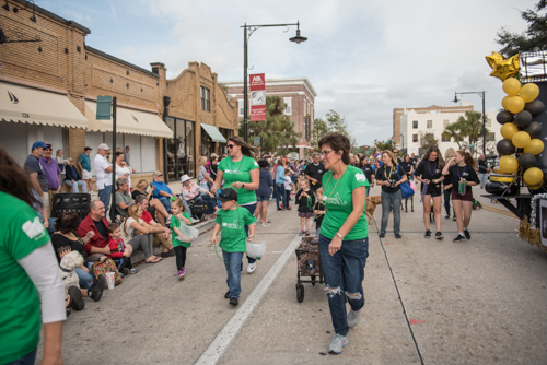 Team Mainstreet handing out candy along the parade route at the Mardi Gras dog parade in DeLand