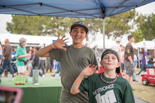 Two kids wave for photo at Pig on the Pond event in Clermont