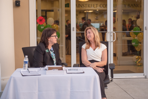 Team Mainstreet sitting outside of Clermont branch chatting while party continues inside