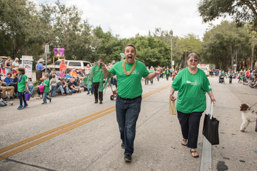 Team Mainstreet handing out beads along the parade route at the Mardi Gras dog parade in DeLand