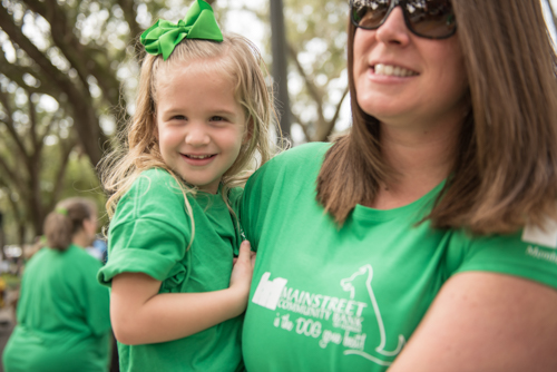 A little girl smiling while being held by her mother before the Mardi Gras on Mainstreet Parade