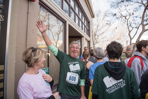 Members of Team Mainstreet smiling and waving for a photo in a crowd after running in the MeStrong 5k race in DeLand