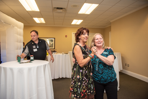 Two members of Team Mainstreet laugh and dance during Clermont's 2nd Anniversary Celebration