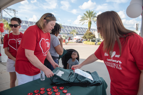 Team Mainstreet handing out bags before the Heart Walk at Daytona International Speedway