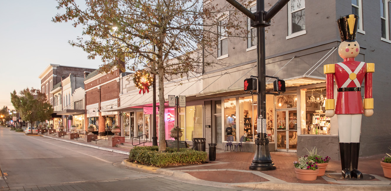 Mainstreet shops lit with Christmas lights as giant toy soldier stands at attention