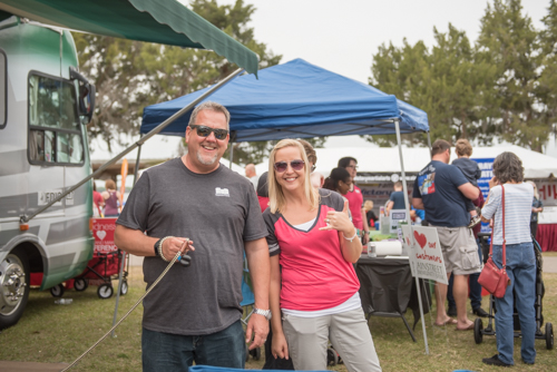 Two members of Team Mainstreet smile for photo as people mingle in background