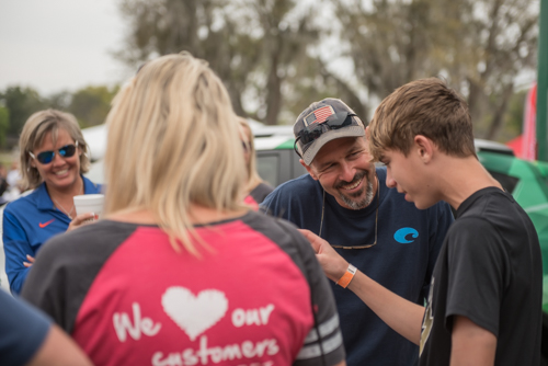 Man laughs with teenager at Pig on the Pond event