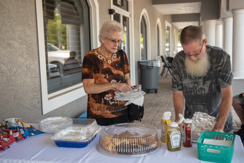 Two customers get toppings and sides for their lunches at Customer Appreciation Day in Holly Hill