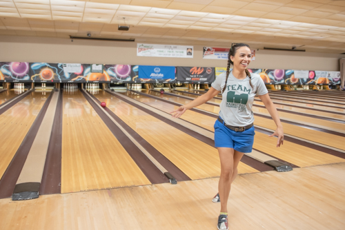 Woman walks away from bowling lane after throwing a gutter ball
