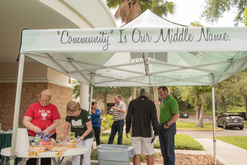 Team members prepare food while customers chat during Mainstreet Community Bank's Customer Appreciation Day