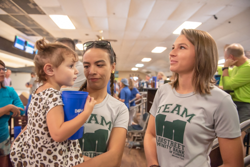 Two woman talk while one of the women holds a little girl