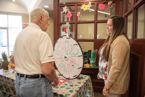A customer and team member chat while the prize wheel spins in background