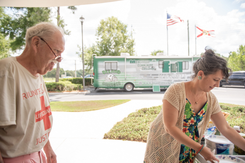 A customer looks on as a Mainstreet Community Bank employee prepares food at Customer Appreciation Day