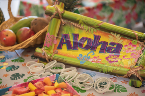 Aloha sign on table with fruit and Mainstreet Community Bank bracelets for kids