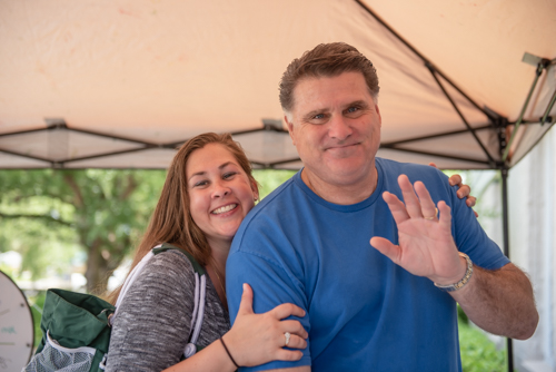 Two customers wave and smile during Orange City's Customer Appreciation