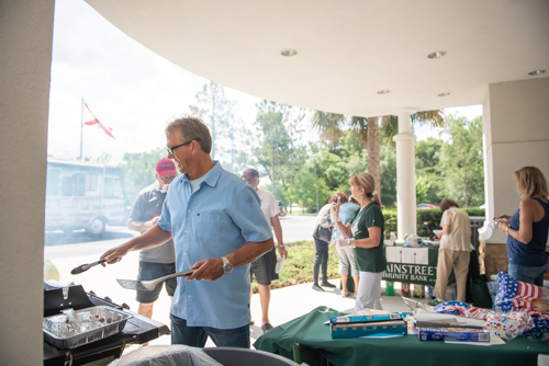 A Mainstreet Community Bank employee prepares lunch on a grill for customers