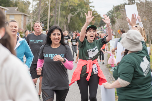 Mainstreet team member high fives cheering squad during MeStrong race