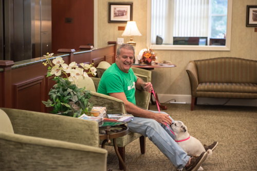 North Spring Garden branch manager plays with customer's dog during customer appreciation day