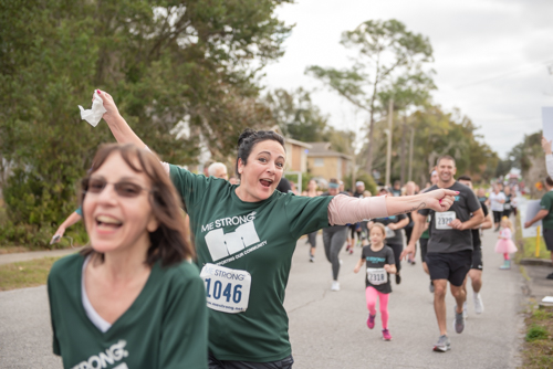 Member of Team Mainstreet cheers as she runs MeStrong race