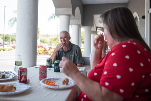 A customer and team member eat together outside Holly Hill's Mainstreet Community Bank location