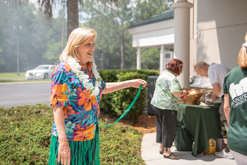 A team member plays with her grass skirt outside during a Luau themed Customer Appreciation Day