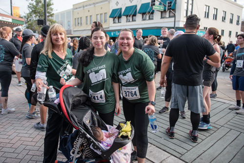 Three women and sleeping baby in stroller after MeStrong race