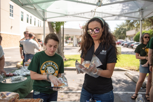 Mainstreet Team Members wrap hotdogs during Customer Appreciation Day