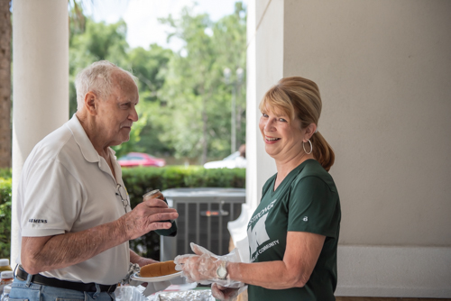 A member of Team Mainstreet laughs with a customer during Customer Appreciation Day