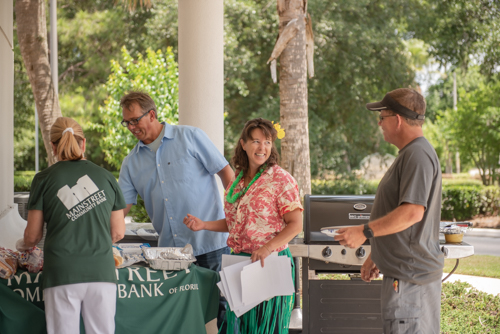 Mainstreet team members and customers chat while preparing food for Customer Appreciation Day in DeLand