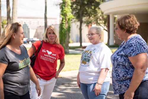 A group of women chat outside Mainstreet Community Bank