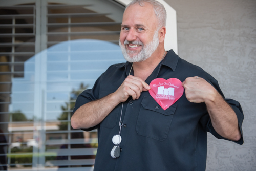 Customer holds promo item shaped as heart against his chest