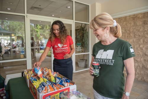 A women chooses a bag of chips at Customer Appreciation Day.