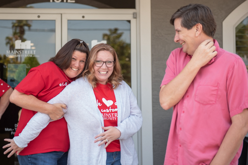 Two Mainstreet Community Bank team members goof off while another looks on at Customer Appreciation Day